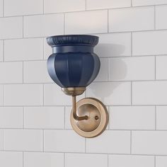 a blue light fixture mounted on a white brick wall