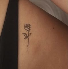 a woman's stomach with a rose tattoo on it