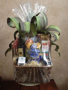 a basket filled with lots of food and drinks on top of a wooden table next to a wall