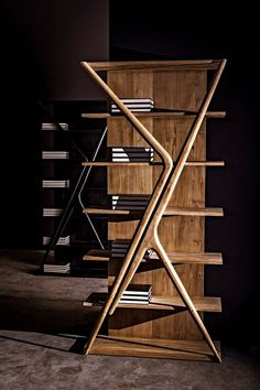 a wooden book shelf with several books on it's sides and two chairs in the background