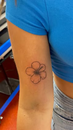 a woman's arm with a flower tattoo on the left side of her body