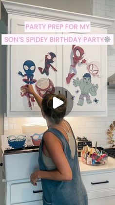 a woman standing in front of a kitchen counter with spiderman magnets on it