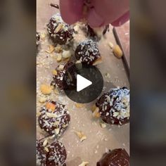 chocolate covered donuts with nuts and sprinkles are being cut in half