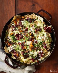 a skillet filled with food on top of a wooden table