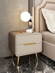 a nightstand with a lamp on top of it next to a night stand and bed