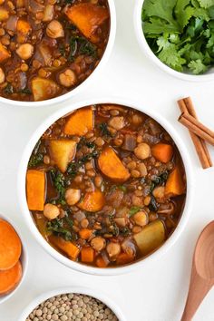 three bowls filled with beans, carrots and spinach on top of a white table