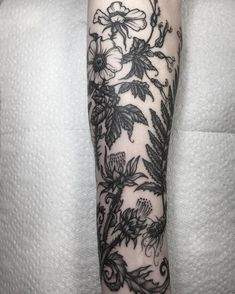 a woman's arm with black and white flowers on the left side of her body