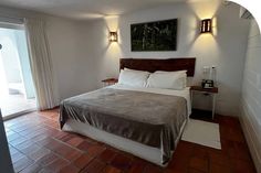 a bed sitting in a bedroom next to a sliding glass door on top of a hard wood floor