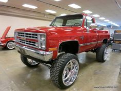 a red truck parked in a garage next to other cars