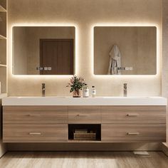 a bathroom with two sinks and mirrors in it's wall - to - wall cabinetry