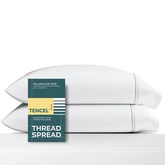 two white pillows sitting next to each other on top of a bed