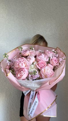 a woman holding a bouquet of pink flowers