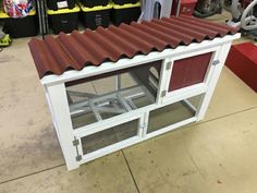 a chicken coop built into the side of a building with red roof tiles on top