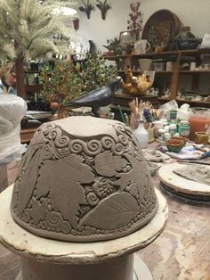 a clay hat sitting on top of a wooden table