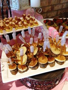 an assortment of desserts displayed on trays at a wedding or event reception table