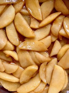 sliced apples are sitting in a bowl with brown liquid on top and the peels have been peeled