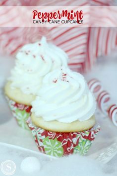 two cupcakes with white frosting and peppermint candy canes in the background