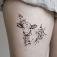 a woman's thigh with a cow and flowers on it