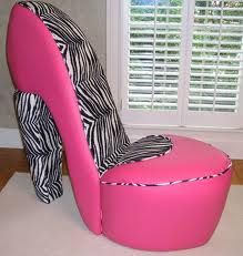 a pink chair sitting in front of a window with zebra print on the seat and back