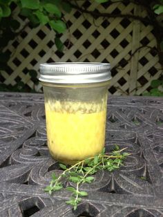 a jar filled with yellow liquid sitting on top of a table