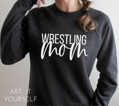 a woman wearing a wrestling mom sweatshirt with the words wrestling mom printed on her back