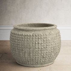 a large planter sitting on top of a wooden floor next to a white wall