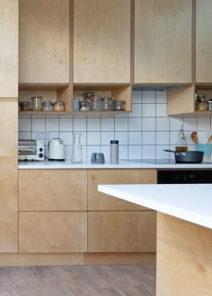 a kitchen with wooden cabinets and white counter tops