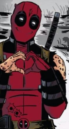 the deadpool is standing in front of some rocks and sand with his hands on his chest