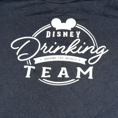 the disney drinking team t - shirt is black with white lettering