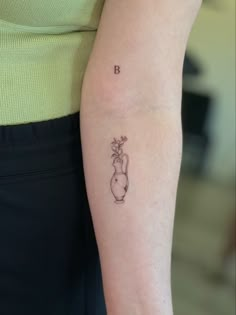 a woman's arm with a small tattoo on the left side of her arm