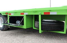 a green flatbed trailer with two tires on the front and rear wheels attached to it