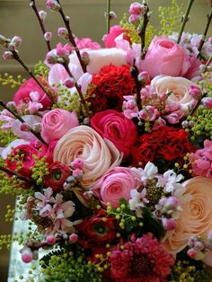 a vase filled with lots of pink and red flowers