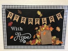 a black and white sign with fall leaves on it that says overflow with hope