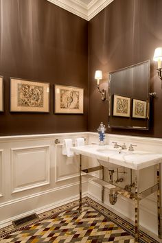 a bathroom with two sinks and three framed pictures