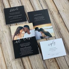 the wedding stationery is laid out on a wooden table with black and white cards