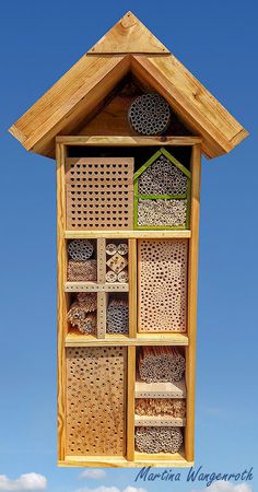 a bird house made out of wood with holes in the roof