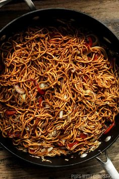 a pan filled with noodles on top of a wooden table