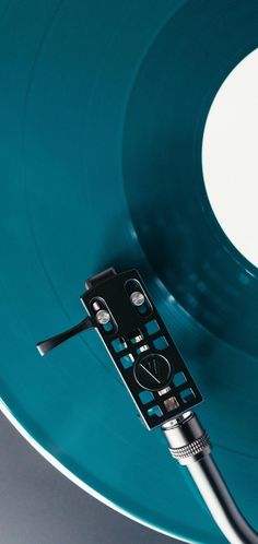 a close up of a remote control on top of a blue vinyl record with white background