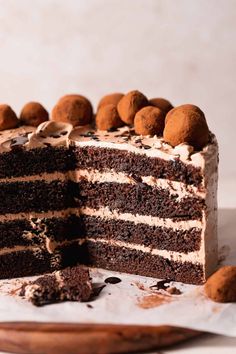 a chocolate cake with white frosting and chocolate balls on top