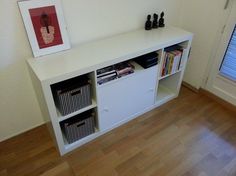 a white shelf with books and magazines on it