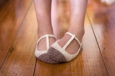 a close up of a person's shoes on a wooden floor