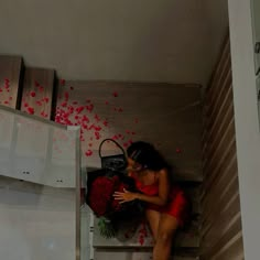 a woman in a red dress is sitting on the stairs