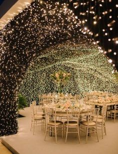 an outdoor dining area is lit up with fairy lights