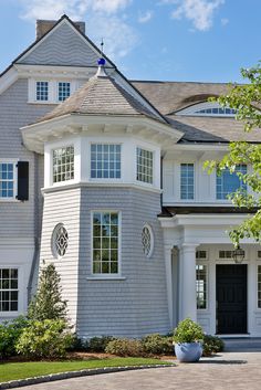 a large gray house with white trim and windows