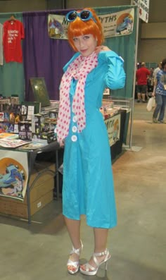 a woman with red hair wearing sunglasses and a blue dress