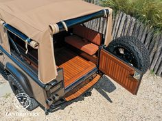 an old jeep with the doors open and wood flooring on it's side