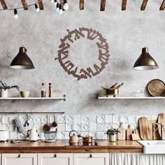 a kitchen with white cabinets and hanging lights above the counter top is decorated with metal letters that spell out love