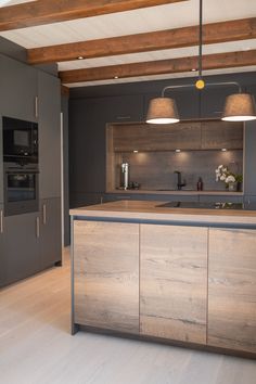 a kitchen with an island and two lights hanging from it's ceiling above the counter