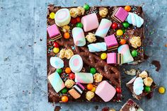 an overhead view of a chocolate cake with marshmallows and candy on it