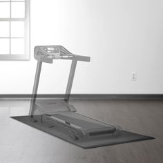 an empty room with a treadmill on the floor